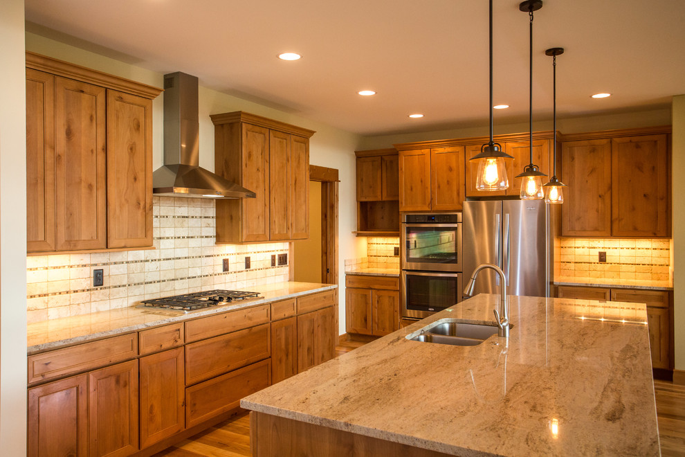 Kitchen pantry - mid-sized rustic l-shaped medium tone wood floor kitchen pantry idea with an undermount sink, recessed-panel cabinets, medium tone wood cabinets, granite countertops, multicolored backsplash, stone tile backsplash, stainless steel appliances and an island