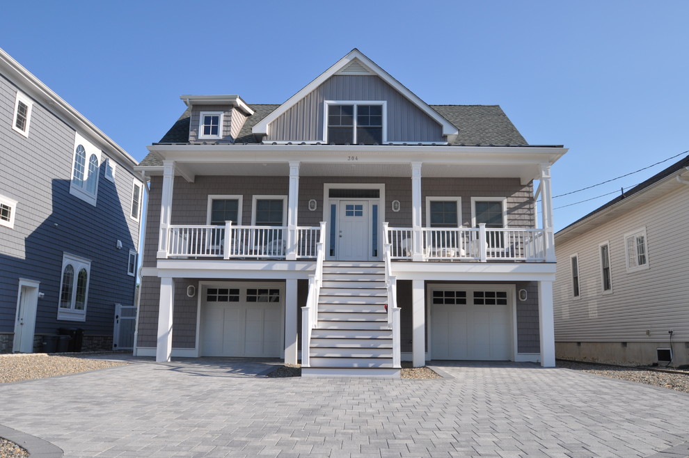 Design ideas for a mid-sized beach style three-storey grey exterior in Other with wood siding and a gable roof.