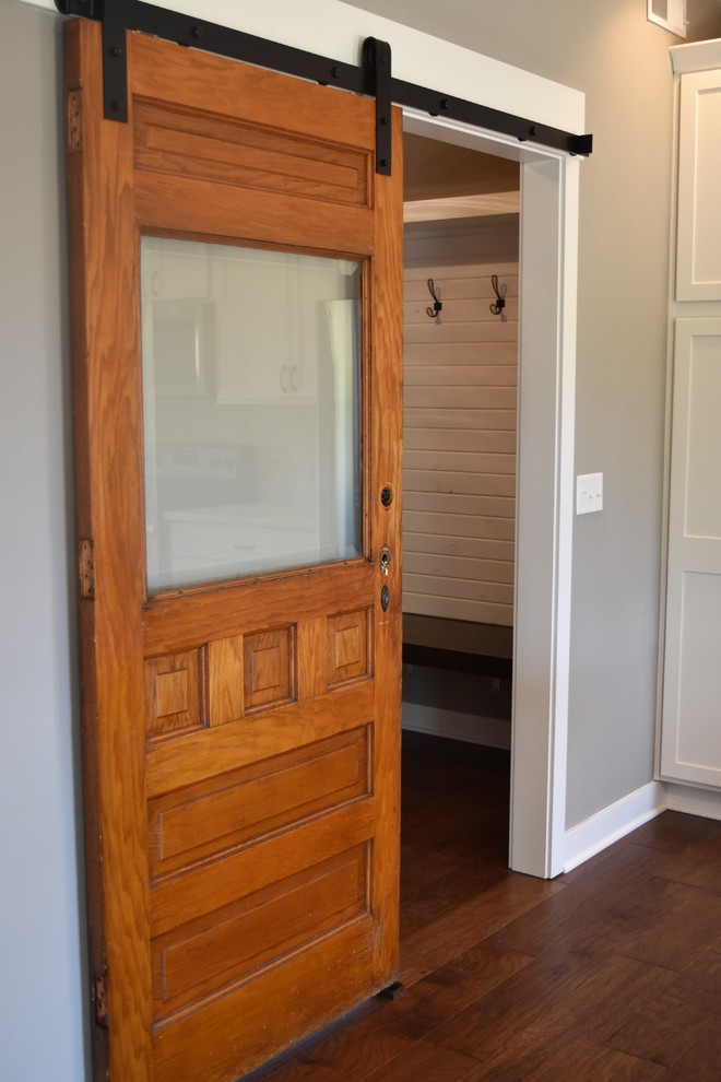 Inspiration for a mid-sized transitional medium tone wood floor and brown floor mudroom remodel with gray walls