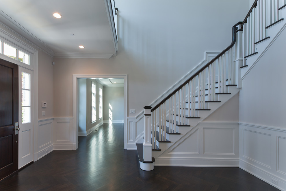 Photo of a mid-sized transitional foyer in New York with grey walls, dark hardwood floors, a single front door and a dark wood front door.