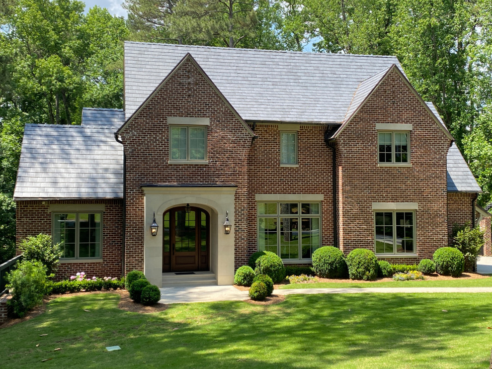 Photo of a large two-storey red house exterior in Atlanta with a tile roof and a grey roof.