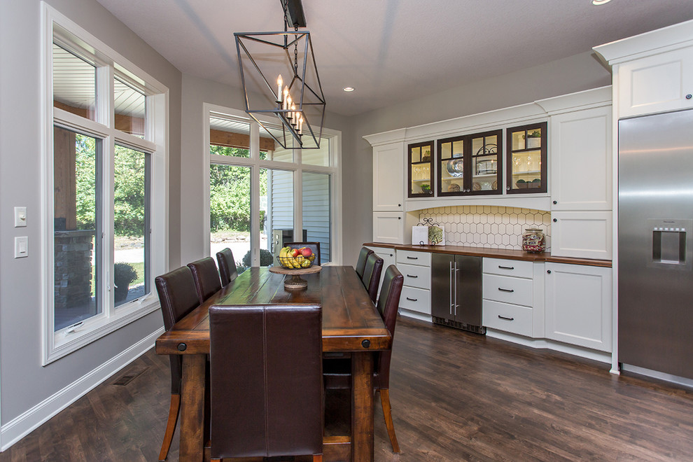 Huge transitional medium tone wood floor kitchen photo with a farmhouse sink, flat-panel cabinets, granite countertops, white backsplash, ceramic backsplash, stainless steel appliances and two islands