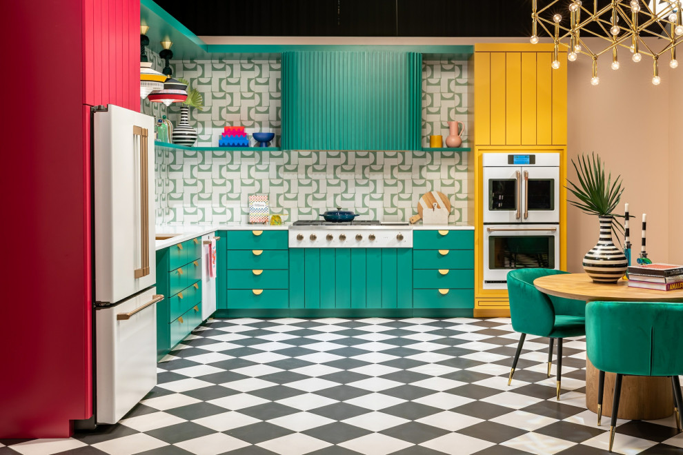 Aménagement d'une grande cuisine américaine moderne en L avec des portes de placard turquoises et une crédence verte.
