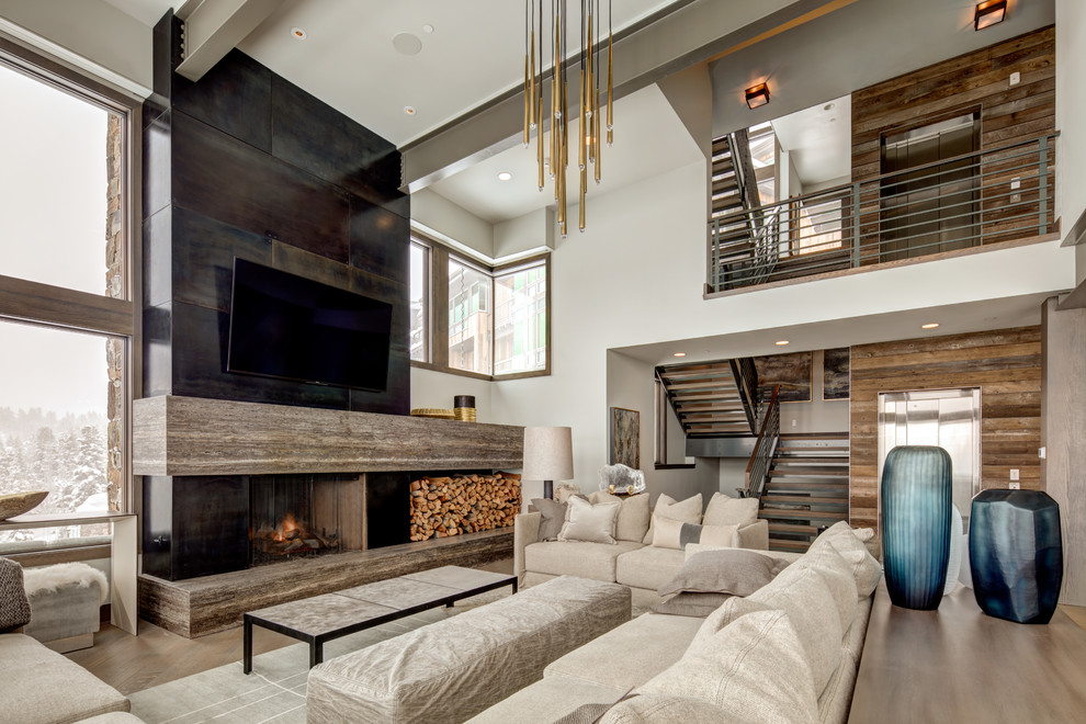 Photo of a large contemporary open concept family room in Salt Lake City with beige walls, a standard fireplace, a wall-mounted tv, dark hardwood floors, a concrete fireplace surround and brown floor.