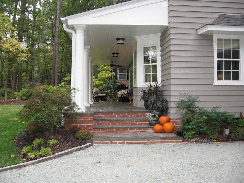 Photo of a mid-sized contemporary verandah in Raleigh with natural stone pavers and a roof extension.