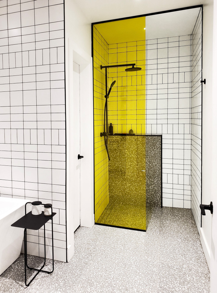 Imagen de cuarto de baño principal minimalista de tamaño medio con bañera exenta, ducha a ras de suelo, paredes blancas, suelo de terrazo, suelo gris y ducha abierta