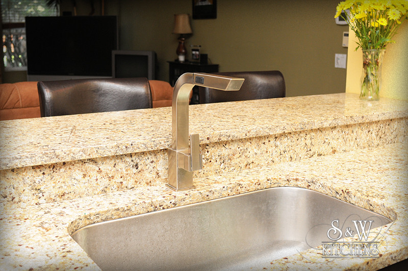 Example of a transitional galley kitchen design in Orlando with a single-bowl sink, shaker cabinets, dark wood cabinets, granite countertops, beige backsplash, mosaic tile backsplash and stainless steel appliances