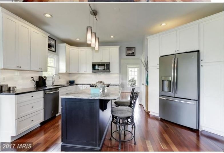 Transitional dark wood floor and brown floor kitchen photo in Baltimore with an undermount sink, raised-panel cabinets, white cabinets, stone tile backsplash and stainless steel appliances