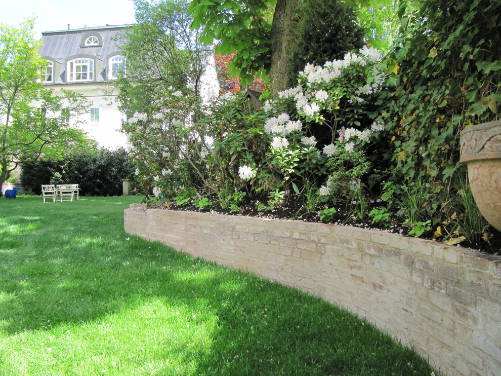 Klassische Gartenmauer im Frühling mit Pflastersteinen in München