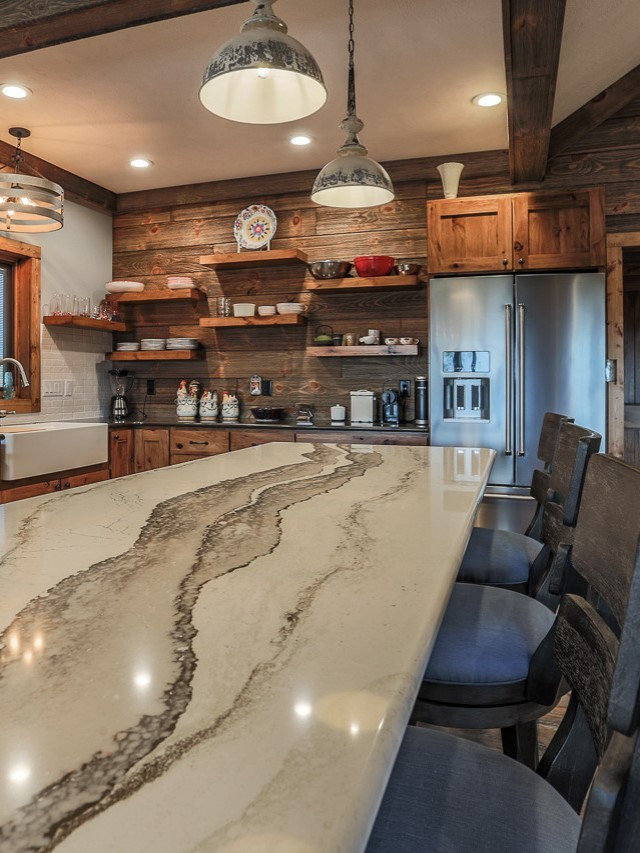 Large country l-shaped open plan kitchen in Omaha with a farmhouse sink, recessed-panel cabinets, medium wood cabinets, quartzite benchtops, white splashback, porcelain splashback, stainless steel appliances, vinyl floors, with island and white benchtop.
