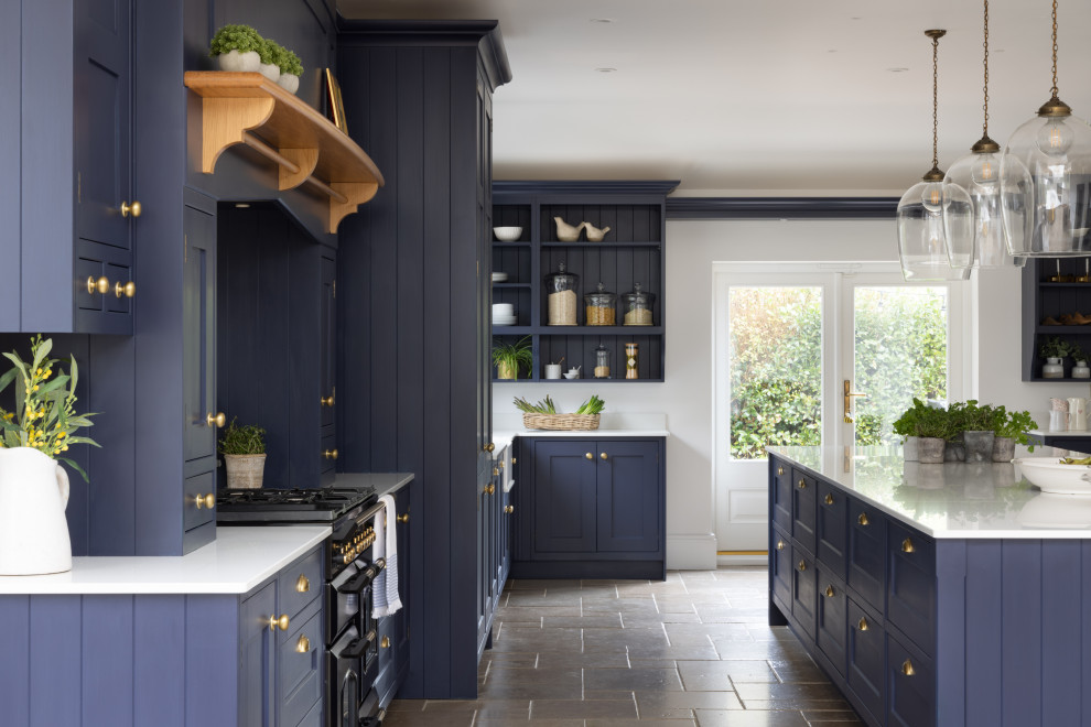 Photo of a large classic kitchen in Hampshire with shaker cabinets, blue cabinets, engineered stone countertops, metallic splashback, an island and white worktops.