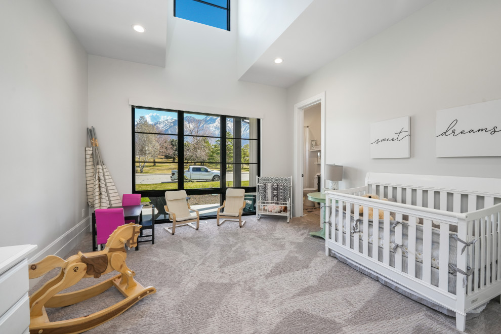 Diseño de habitación de bebé neutra clásica grande con paredes blancas, moqueta y suelo gris