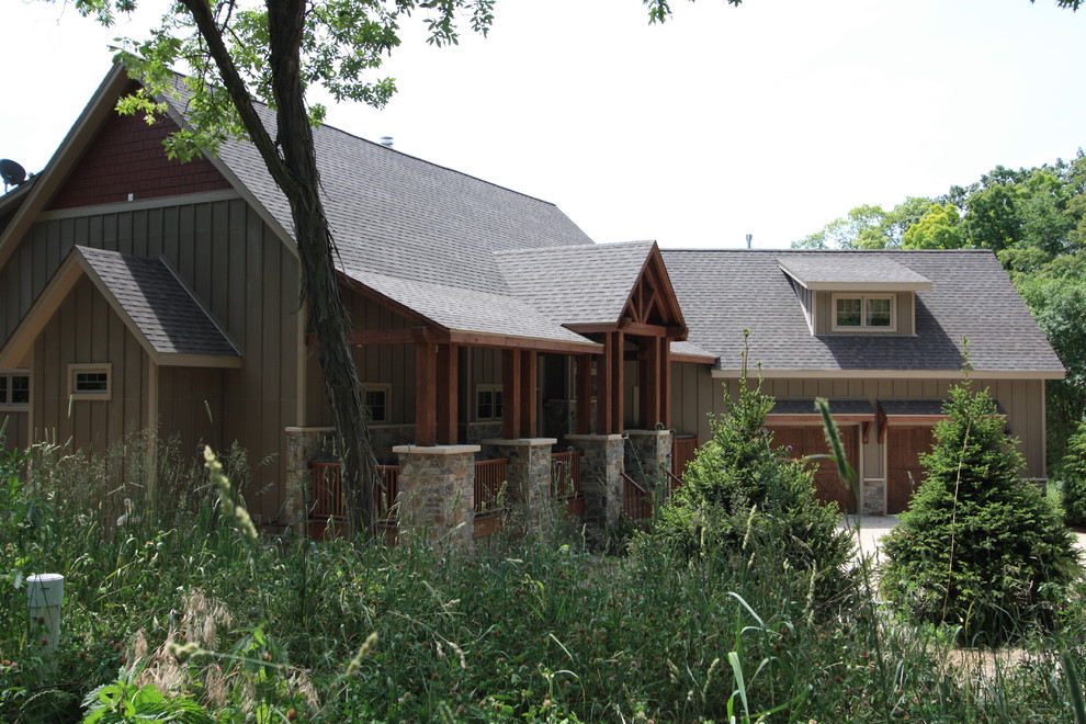 Photo of a large traditional two-storey stucco brown exterior in Milwaukee with a shed roof.