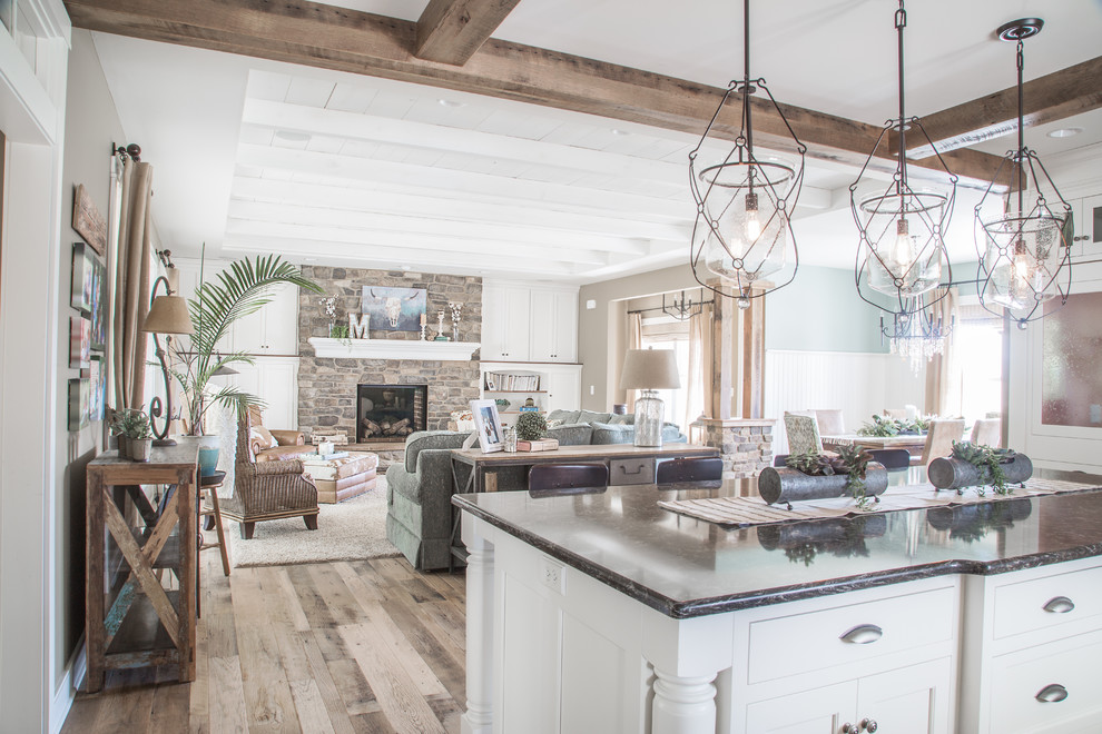 Eat-in kitchen - country l-shaped light wood floor, brown floor and exposed beam eat-in kitchen idea with beaded inset cabinets, white cabinets, gray backsplash, brick backsplash, an island, multicolored countertops, an undermount sink and stainless steel appliances