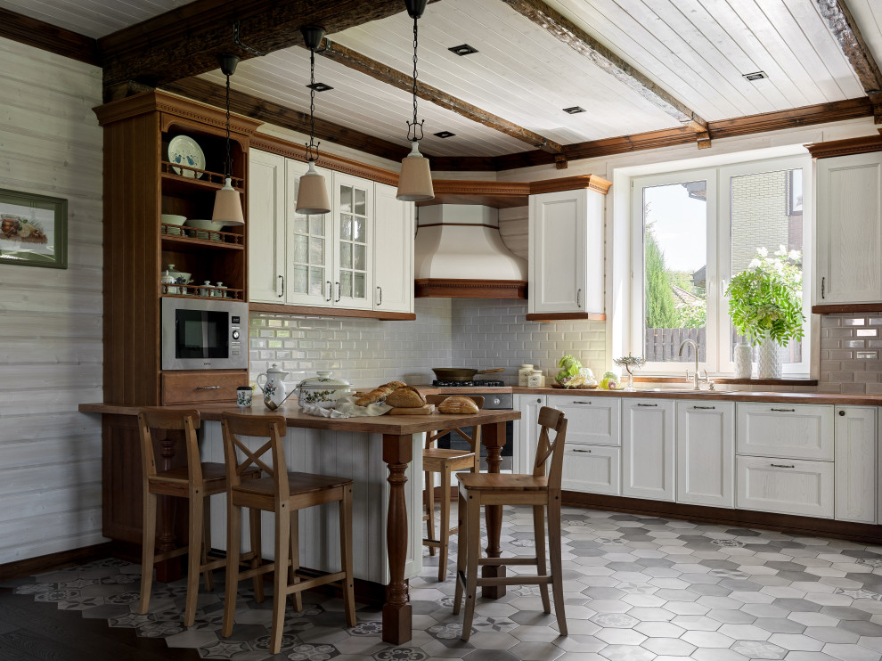 Inspiration för mellanstora klassiska brunt kök, med en undermonterad diskho, luckor med profilerade fronter, vita skåp, träbänkskiva, vitt stänkskydd, stänkskydd i keramik, rostfria vitvaror, klinkergolv i keramik, en halv köksö och grått golv
