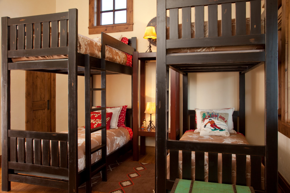 This is an example of a mid-sized traditional gender-neutral kids' bedroom for kids 4-10 years old in Other with beige walls and light hardwood floors.