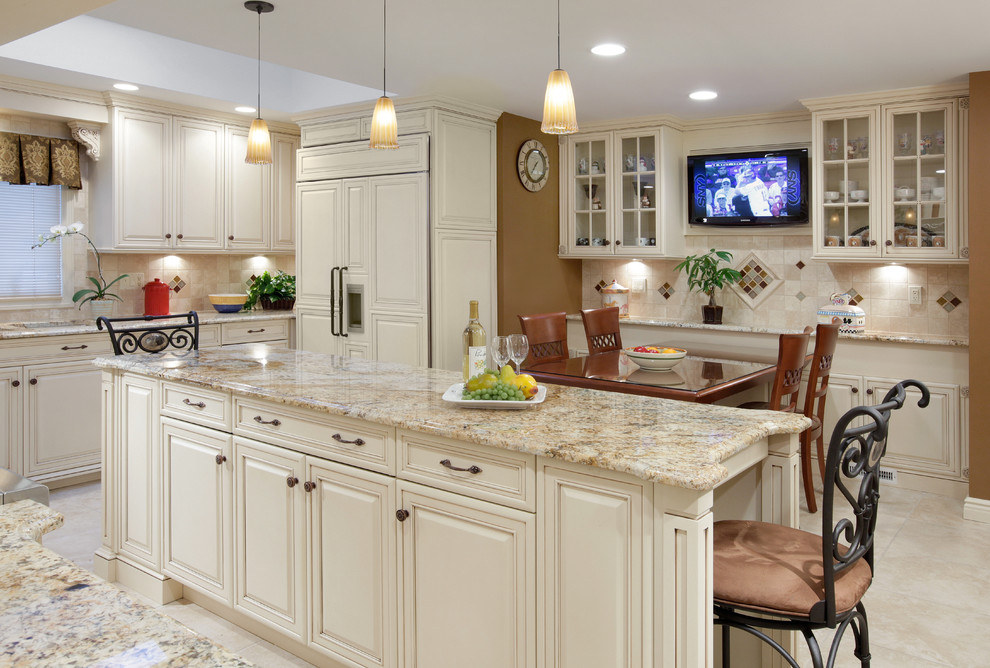 This is an example of a mid-sized traditional l-shaped eat-in kitchen in New York with an undermount sink, raised-panel cabinets, beige cabinets, granite benchtops, beige splashback, stone tile splashback, panelled appliances, porcelain floors and with island.