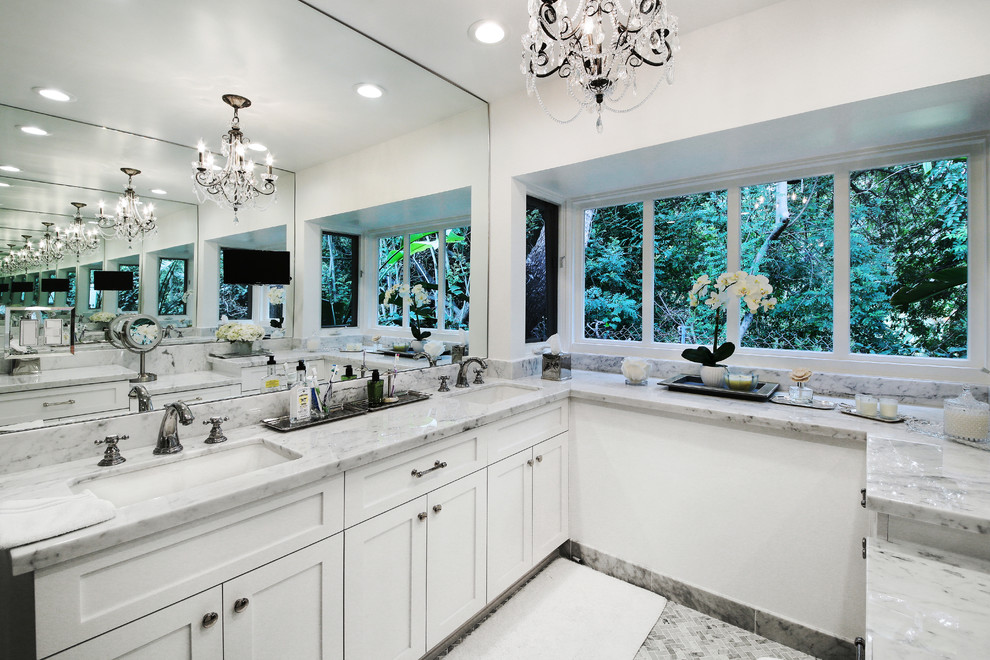 Design ideas for a transitional master bathroom in Los Angeles with an undermount sink, recessed-panel cabinets, white cabinets, marble benchtops, a corner shower, a two-piece toilet, white tile, stone tile and marble floors.