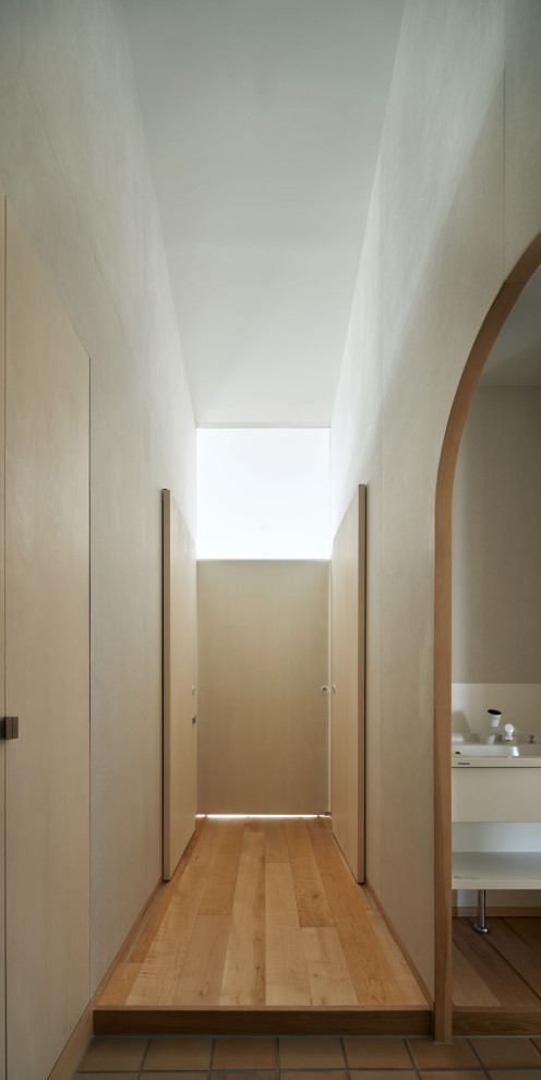 Imagen de hall abovedado y gris escandinavo pequeño con paredes grises, suelo de madera clara, puerta corredera, puerta de madera clara, suelo beige y panelado