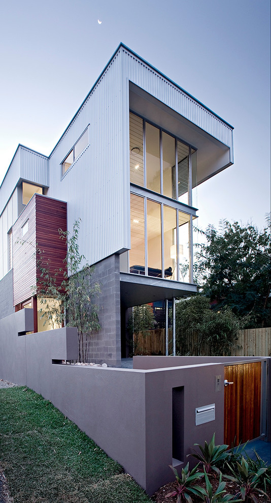 This is an example of a contemporary three-storey multi-coloured exterior in Brisbane with mixed siding and a flat roof.