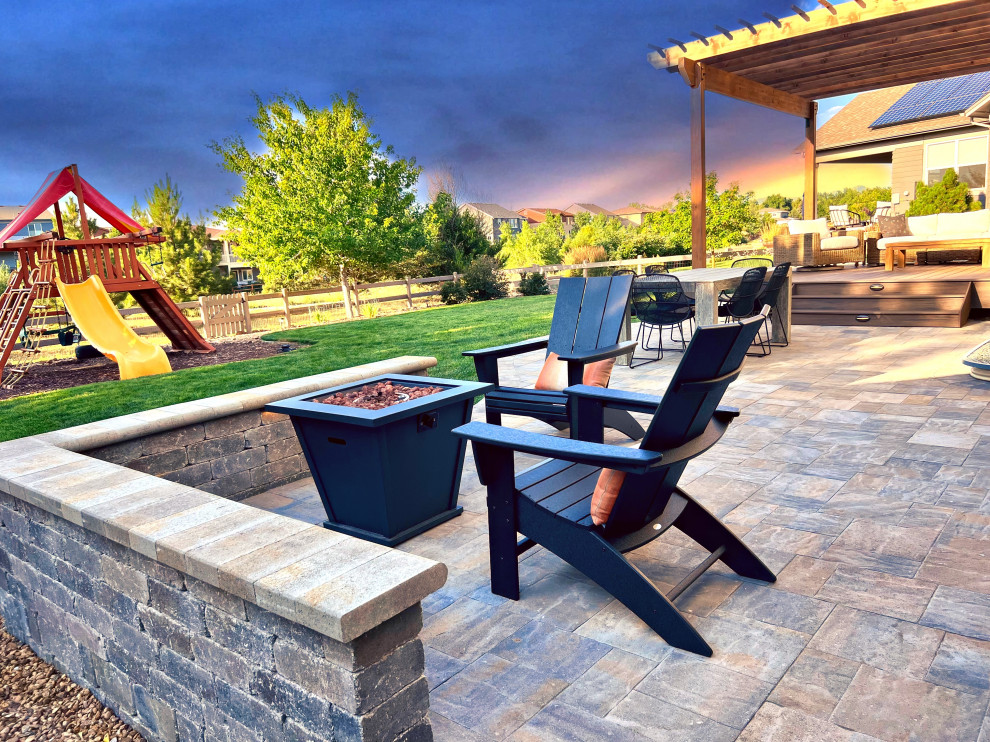 Inspiration for a mid-sized contemporary backyard patio in Denver with a fire feature, natural stone pavers and a pergola.