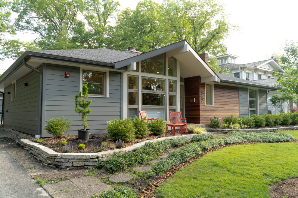 Photo of a small midcentury one-storey grey house exterior in Chicago with concrete fiberboard siding, a hip roof, a shingle roof, a grey roof and clapboard siding.