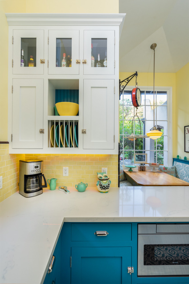 Design ideas for a small country u-shaped eat-in kitchen in Los Angeles with a farmhouse sink, beaded inset cabinets, blue cabinets, quartz benchtops, yellow splashback, subway tile splashback, white appliances, cement tiles, blue floor and white benchtop.