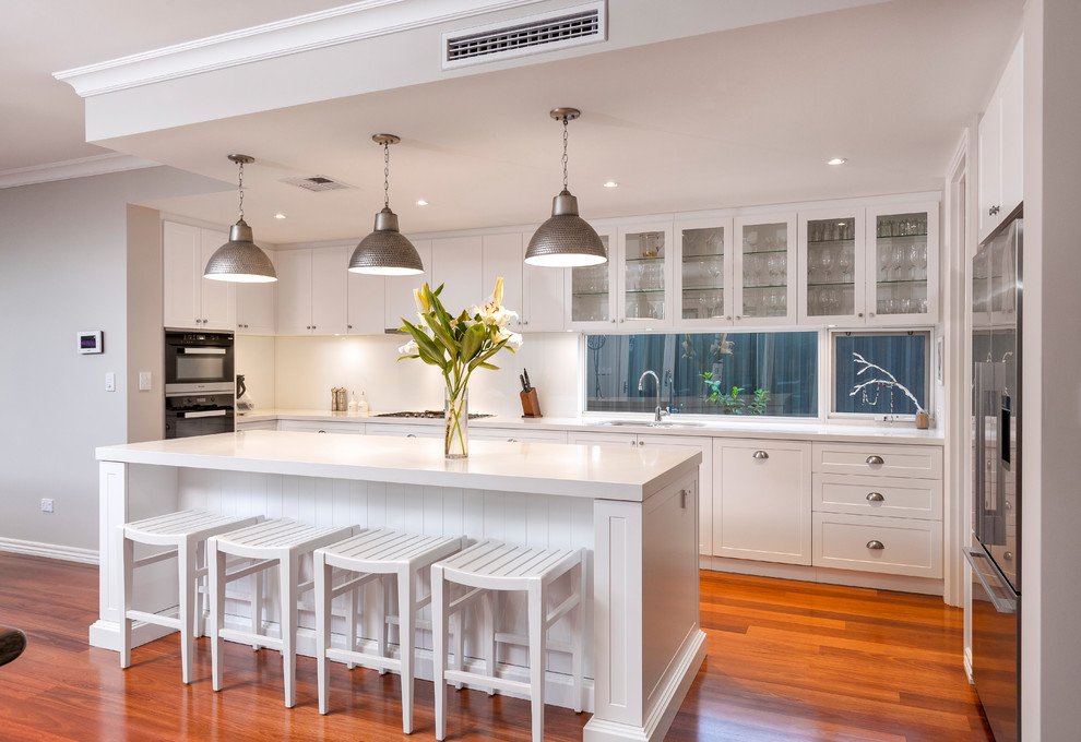 Design ideas for a transitional single-wall separate kitchen in Perth with shaker cabinets, white cabinets, window splashback, black appliances, medium hardwood floors, with island and orange floor.