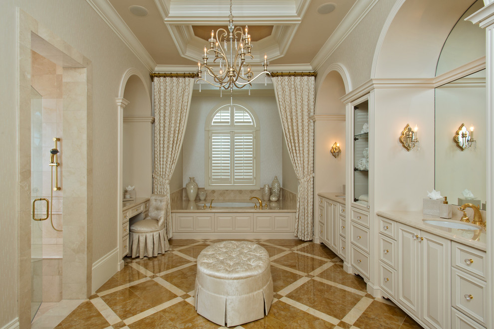 Inspiration for a traditional master wet room bathroom in Other with beige walls, raised-panel cabinets, beige cabinets, an alcove tub, beige tile, an undermount sink, beige floor, a hinged shower door and beige benchtops.