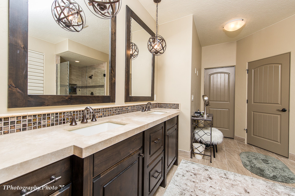 Design ideas for a large traditional master bathroom in Salt Lake City with furniture-like cabinets, dark wood cabinets, beige walls, an undermount sink, beige floor, brown tile, glass tile, porcelain floors and limestone benchtops.