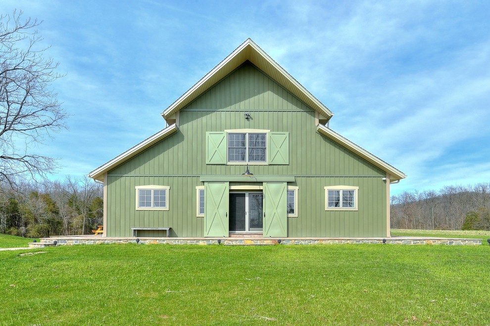 Design ideas for a mid-sized country two-storey green exterior in Other with wood siding and a gable roof.