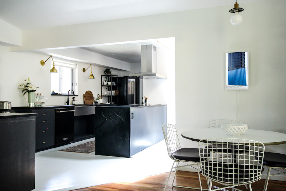 Mid-sized scandinavian galley eat-in kitchen in Boise with a farmhouse sink, flat-panel cabinets, grey cabinets, soapstone benchtops, white splashback, window splashback, black appliances, painted wood floors, a peninsula and white floor.