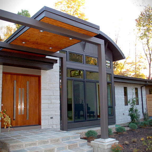 Large modern one-storey beige house exterior in Cleveland with stone veneer and a flat roof.
