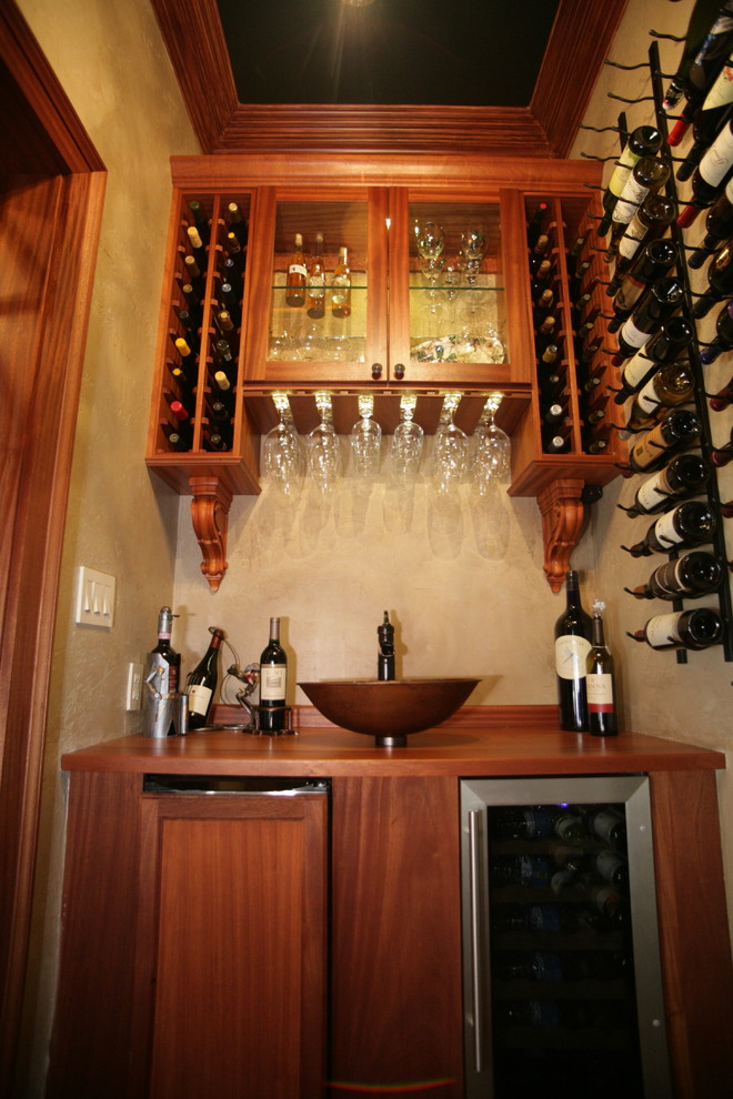 Design ideas for a small mediterranean wine cellar in Other with medium hardwood floors, storage racks and brown floor.