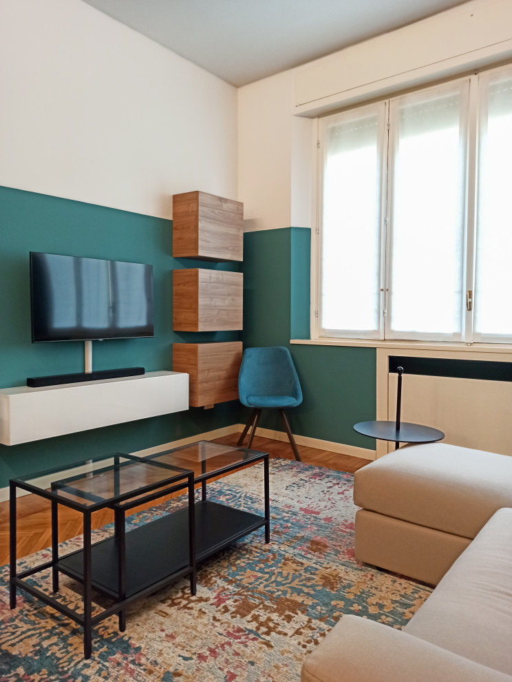 Свежая идея для дизайна: изолированная гостиная комната среднего размера в современном стиле с зелеными стенами, темным паркетным полом, коричневым полом, мультимедийным центром и панелями на части стены - отличное фото интерьера