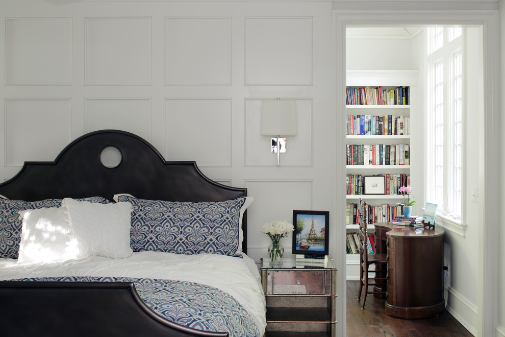 This is an example of a traditional bedroom in Raleigh with dark hardwood floors and white walls.