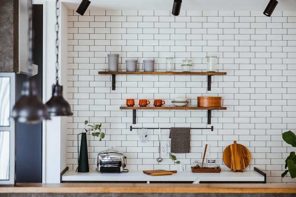 他の地域にあるインダストリアルスタイルのおしゃれなキッチン (濃色無垢フローリング、茶色い床、白いキッチンカウンター) の写真