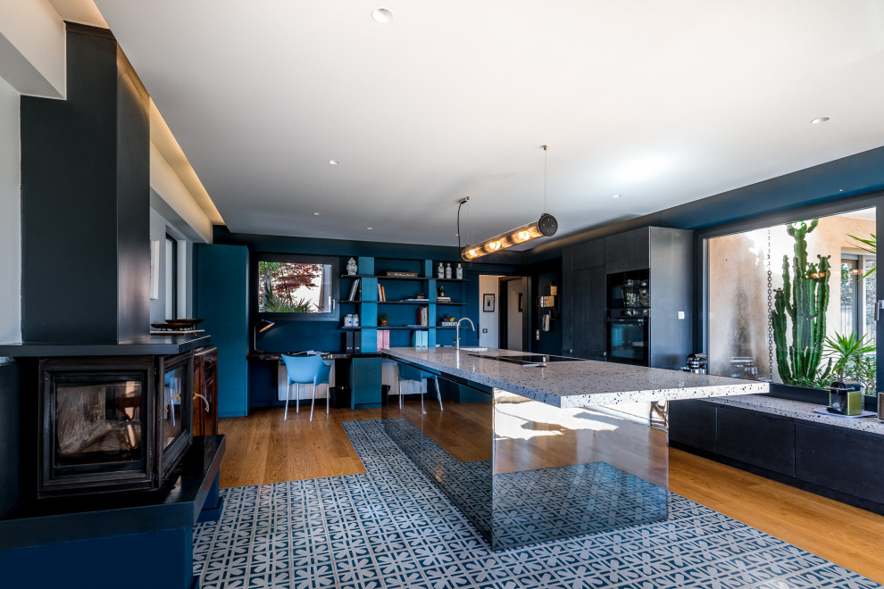 Design ideas for a mid-sized contemporary galley open plan kitchen in Marseille with an integrated sink, glass-front cabinets, black cabinets, terrazzo benchtops, black appliances, cement tiles, with island, blue floor and blue benchtop.