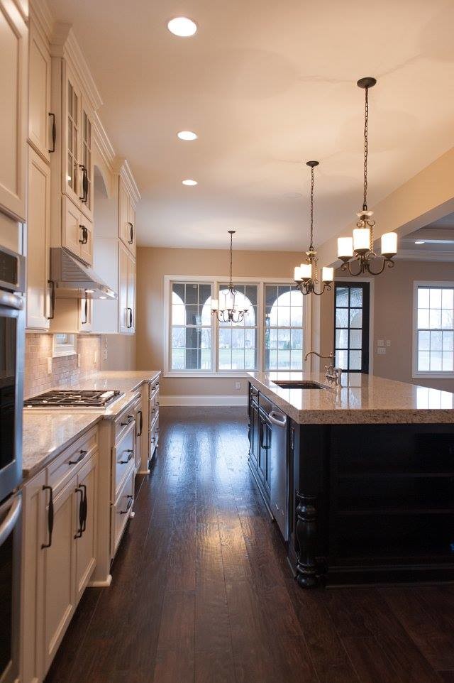 Open concept kitchen - transitional l-shaped open concept kitchen idea in Indianapolis with an undermount sink, shaker cabinets, white cabinets, granite countertops, white backsplash, stone tile backsplash, stainless steel appliances and an island