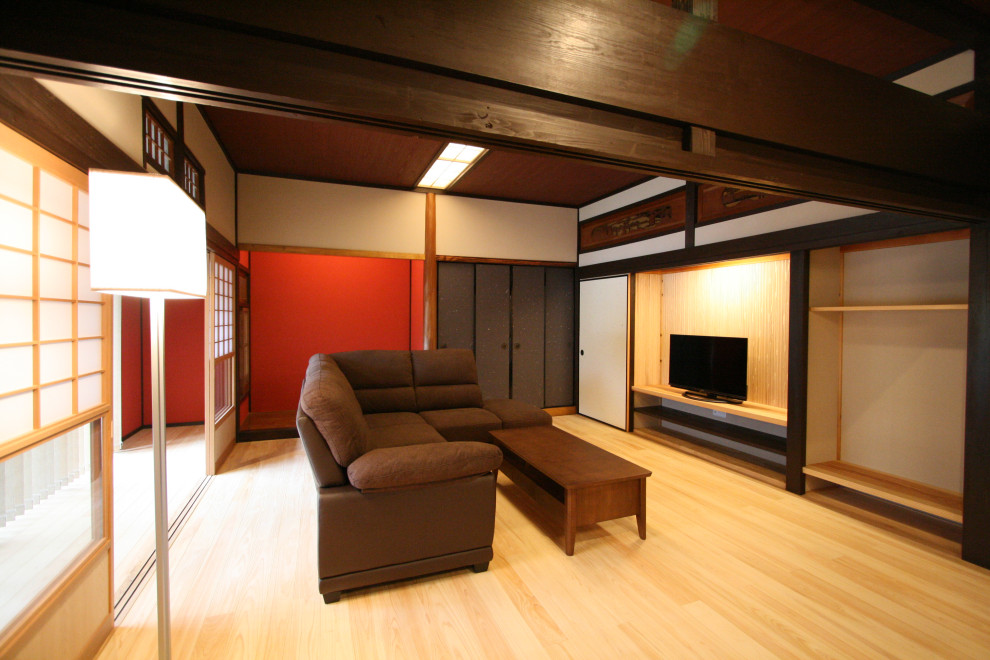 Пример оригинального дизайна: большая открытая гостиная комната в восточном стиле с коричневыми стенами, светлым паркетным полом, отдельно стоящим телевизором, бежевым полом и деревянным потолком без камина