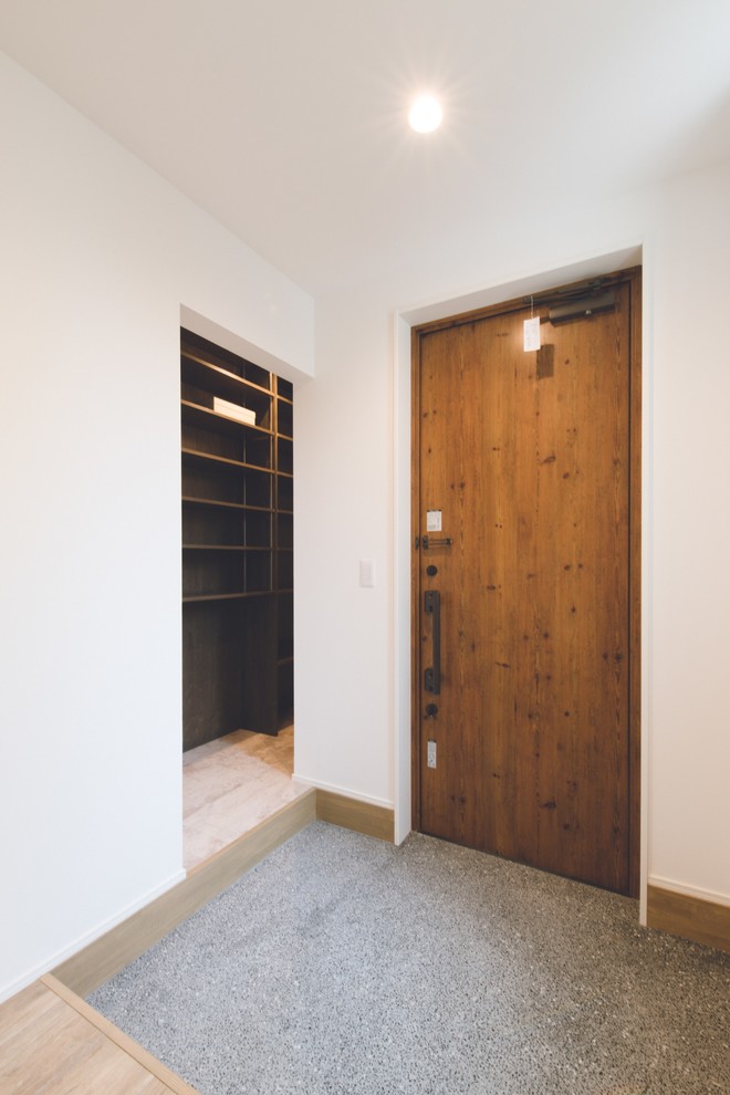 This is an example of a mid-sized scandinavian entryway in Sapporo with white walls, granite floors, a single front door and a medium wood front door.