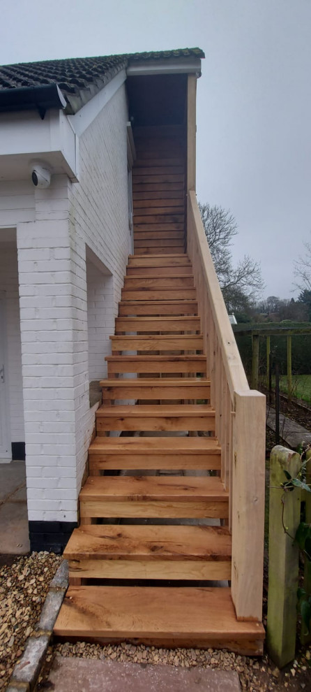 Modelo de escalera recta clásica grande con escalones de madera, contrahuellas de madera, barandilla de madera y madera