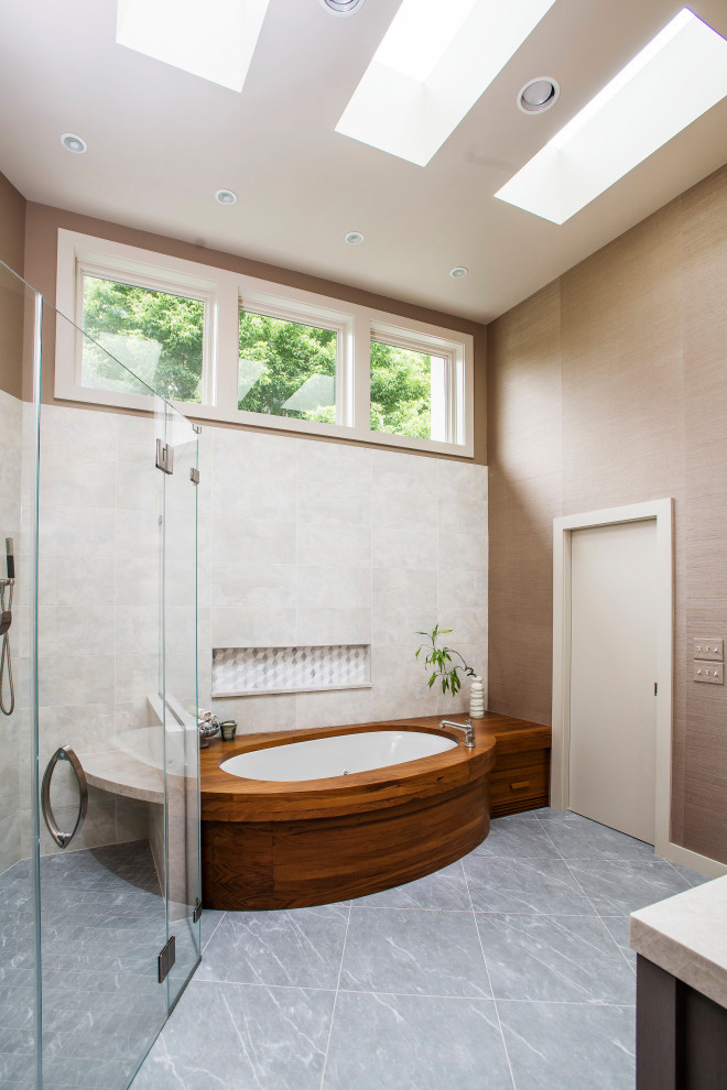 This is an example of a modern master bathroom in Baltimore with an undermount tub, a curbless shower, white tile, ceramic tile, brown walls, ceramic floors, grey floor and a hinged shower door.