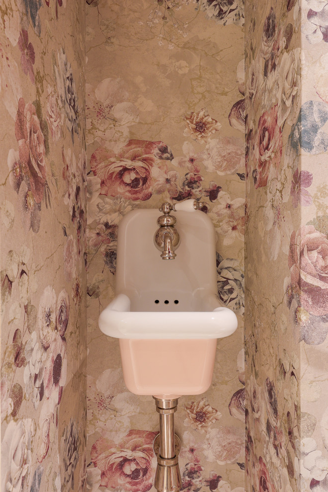 This is an example of a medium sized traditional cloakroom in Nice with beaded cabinets, beige cabinets, a wall mounted toilet, multi-coloured walls, terrazzo flooring, a built in vanity unit, a wallpapered ceiling, a wall-mounted sink, white floors and wallpapered walls.