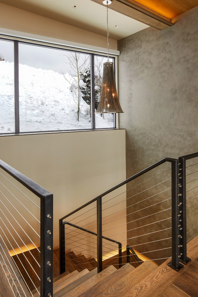 Photo of a mid-sized country wood floating staircase in Denver with open risers and cable railing.