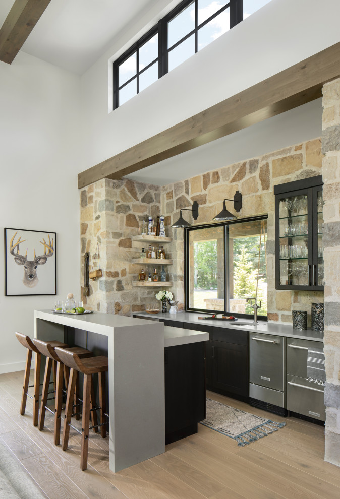 Example of a cottage galley light wood floor and beige floor seated home bar design in Denver with an undermount sink, shaker cabinets, black cabinets, brown backsplash and gray countertops