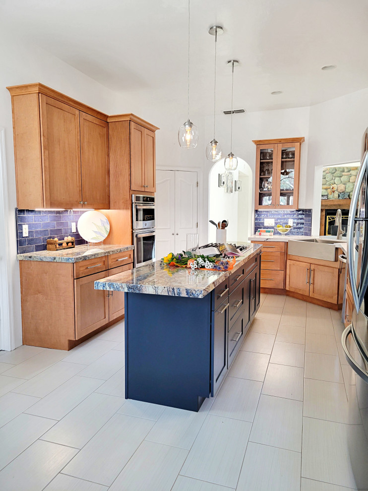 This is an example of a medium sized country u-shaped kitchen/diner in Sacramento with a belfast sink, shaker cabinets, blue cabinets, granite worktops, blue splashback, ceramic splashback, stainless steel appliances, ceramic flooring, an island, beige floors and blue worktops.