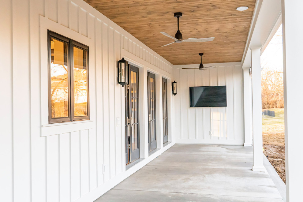 Inspiration for a large country one-storey white house exterior in St Louis with concrete fiberboard siding, a gable roof, a mixed roof, a black roof and board and batten siding.