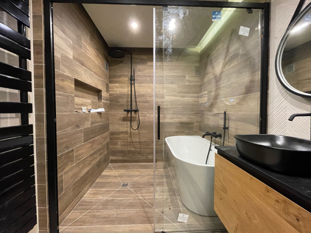Modern inredning av ett mellanstort svart svart en-suite badrum, med svarta skåp, ett fristående badkar, våtrum, beige kakel, beige väggar, ett nedsänkt handfat, kaklad bänkskiva och dusch med skjutdörr