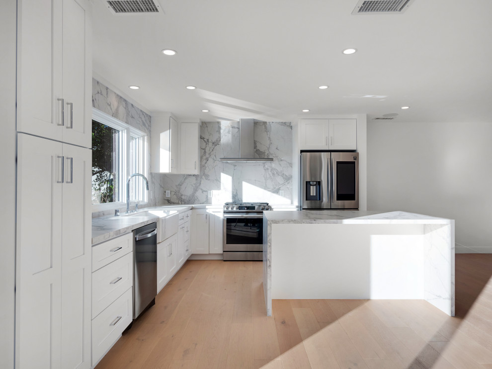 Idéer för att renovera ett mellanstort lantligt grå grått kök, med en rustik diskho, skåp i shakerstil, vita skåp, marmorbänkskiva, grått stänkskydd, stänkskydd i marmor, rostfria vitvaror, ljust trägolv, en köksö och beiget golv